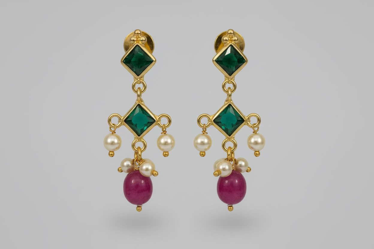 Gold earrings with green, red, and pearl-like beads on a white background