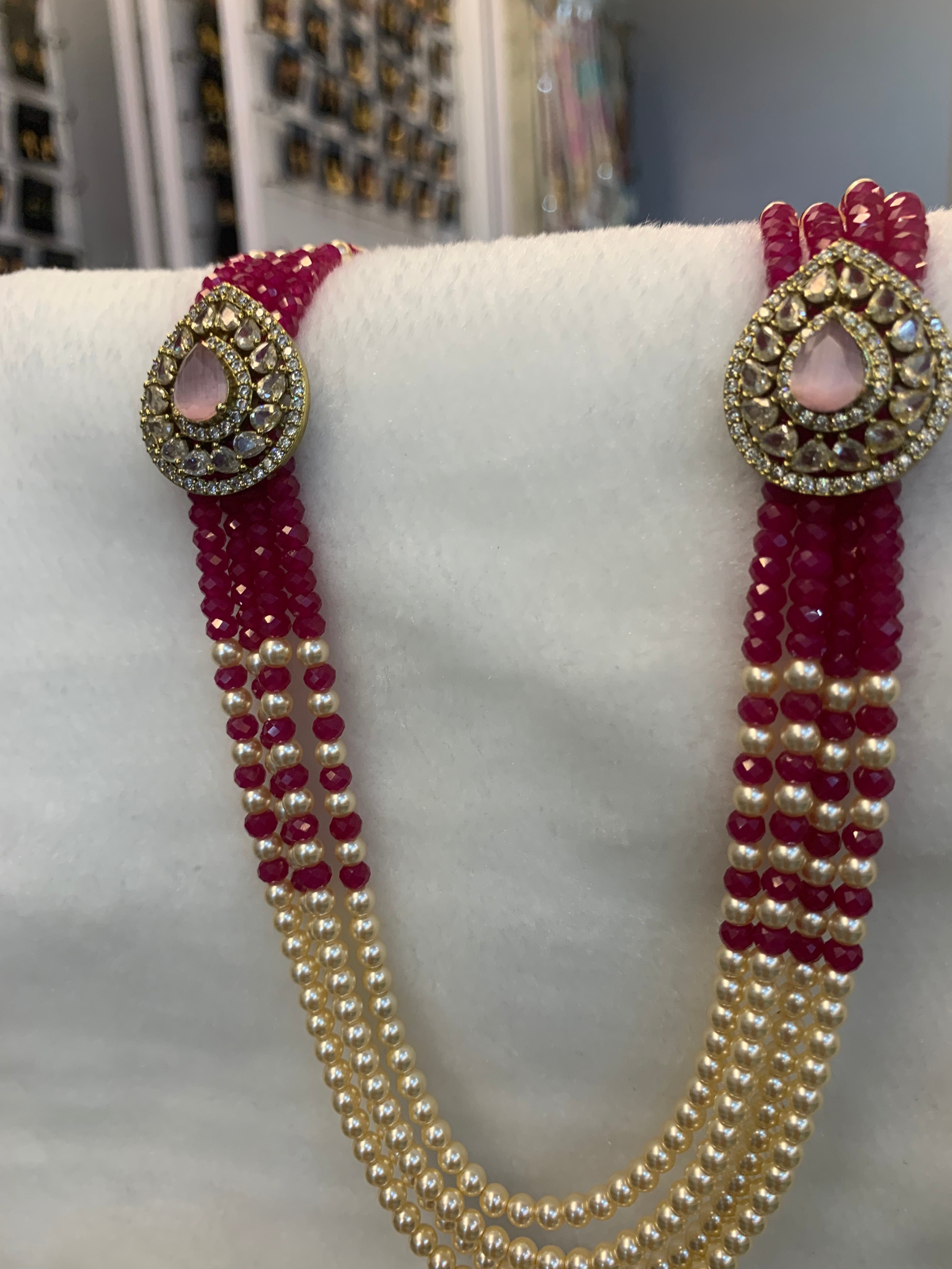 Beaded belt with gold and red accents on a mannequin.