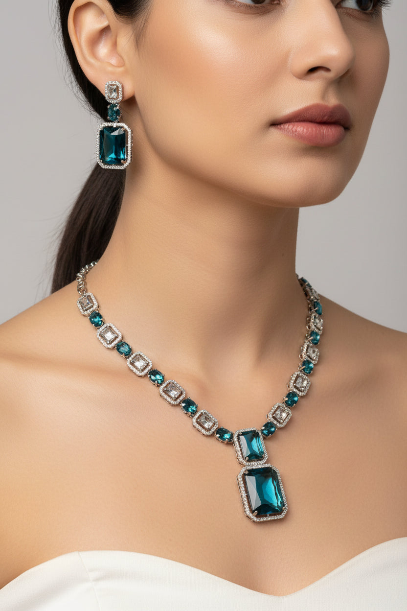 Woman wearing a blue gemstone necklace and earrings on a plain background